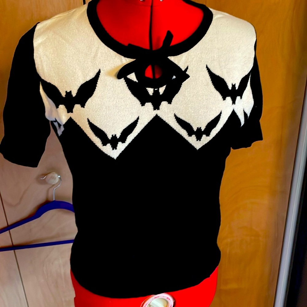 Hell Bunny white and black knit top with bat details and black bow.